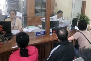 Cán bộ phường Hoàng Liệt, quận Hoàng Mai làm thủ tục hành chính cho người dân sáng 20-3.