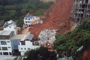 Nhiều căn nhà được xây dựng giữa vách đồi, phía sau là những taluy cùng với những công trình khác.