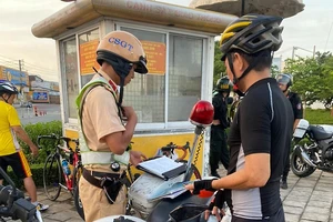 CSGT lập biên bản đối với một người điều khiển xe đạp vi phạm giao thông.