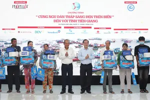 Ông Trương Hòa Bình, nguyên Ủy viên Bộ Chính trị, nguyên Phó Thủ tướng thường trực Chính phủ, cùng lãnh đạo tỉnh Tiền Giang trao quà cho ngư dân.