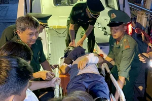 Lực lượng chức năng đưa ngư dân Quảng Ngãi bị hành hung trên biển đi điều trị.