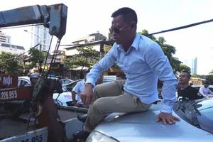 Tài xế 'cố thủ' trên nắp capo khi xe bị cẩu đi