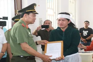 Thứ trưởng Bộ Công an Lê Tấn Tới trao quyết định thăng cấp bậc hàm cho vợ Thiếu tá Nguyễn Thanh Hải (cán bộ Công an phường An Hội, TP Cần Thơ) hy sinh trong lúc làm nhiệm vụ. Ảnh: PLO