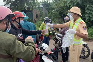CSGT dẫn đường, phát nước và bánh mì miễn phí cho người dân về quê