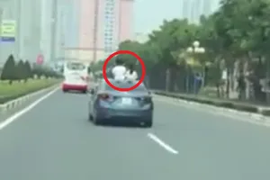 Để 2 trẻ nhỏ đứng ở cửa sổ trời ô tô chạy trên xa lộ