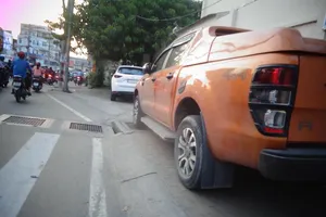 Đậu xe ô tô chiếm vỉa hè, đè nắp hố ga