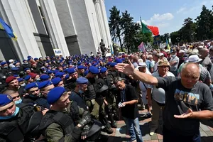 Lực lượng an ninh Ukraine (bên trái) bảo vệ tòa nhà quốc hội Ukraine hôm 14-7 trước cuộc biểu tình của hàng trăm cảnh sát đã về hưu. Ảnh: AFP