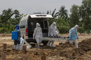 Nhân viên y tế Malaysia chôn cất một người chết vì COVID-19. Ảnh: EPA-EFE
