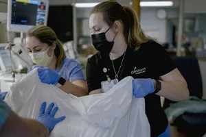 Nhân viên tại một cơ sở y tế ở Saginaw, bang Michigan, Mỹ đưa bệnh nhân COVID-19 nặng sang phòng chăm sóc đặc biệt. Ảnh: THE NEW YORK TIMES