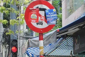 Tờ rơi nương mình che biển báo giao thông