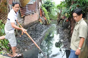 Ông Sang đi dọn kênh, chống ngập 