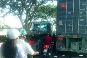 Xe máy chen đường với xe tải