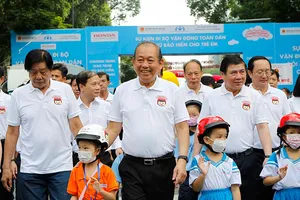 Phó Thủ tướng Trương Hòa Bình vận động đội mũ bảo hiểm cho trẻ