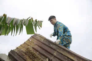 Các chiến sĩ Sư đoàn Không quân 372 sửa lại nhà cho người dân bị thiệt hại do vụ máy bay Su-22 rơi hôm 9-1. Ảnh: TN