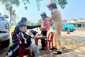 CSGT Quảng Nam phát nước, khăn lạnh cho người dân về quê nghỉ lễ. Ảnh: TN