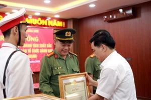 Phó Bí thư Thường trực Tỉnh uỷ Quảng Nam Lê Văn Dũng tặng bằng khen, thưởng nóng cho các cá nhân, đơn vị phá đường dây đánh bạc 20 tỉ đồng mỗi ngày. Ảnh: TN