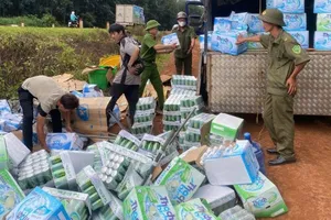 Công an cùng người dân hỗ trợ tài xế gom hàng hóa trên xe tải bị lật 