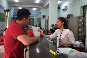 Công chức Tư pháp - Hộ tịch phường 3 (Gò Vấp) hướng dẫn người dân làm thủ tục khai sinh. Ảnh: TRÚC PHƯƠNG