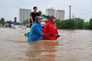 Nhiều tuyến đường Hà Nội biến thành sông, dân phải thuê 'phà người' qua điểm ngập