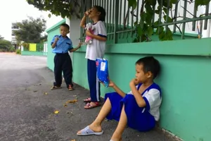 Học sinh vạ vật quanh cổng trường chờ học buổi hai
