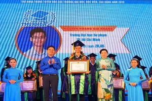 Nguyễn Hoàng Gia Khánh nhận bằng khen và vòng hoa tại lễ vinh danh thủ khoa. Ảnh: Nguyễn Quyên