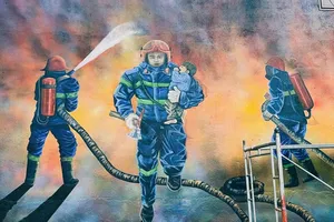 Một người dân ở TP Đà Lạt phủ kín bức tường hình 3 chiến sĩ PCCC hy sinh 