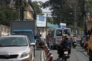 Vô tư băng qua đường mặc hàng rào chắn