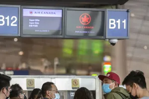  Hành khách của hãng hàng không Air Canada tăng cường đeo khẩu trang ngừa dịch Corona, ảnh chụp tại Trung Quốc. Ảnh: SPUTNIK