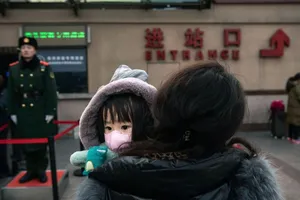 Một em bé cùng mẹ đứng đợi ở tàu ở ga Bắc Kinh ngày 1-2. Ảnh: GETTY IMAGES