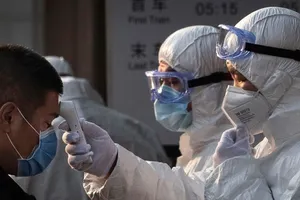 Nhân viên y tế Trung Quốc kiểm tra thân nhiệt của hành khách tại một ga tàu ở thủ đô Bắc Kinh (Ảnh chụp ngày 4-2). Ảnh: AFP