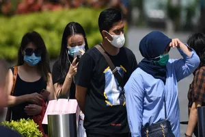  Người dân Singapore đeo khẩu trang trên đường phố ngày 4-2. Ảnh: GETTY IMAGES 