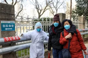 Các nhân viên y tế hướng dẫn người dân đến điểm tập trung phòng-chống dịch ở Vũ Hán. Ảnh: REUTERS