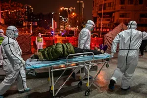 Nhân viên y tế đang đưa một bệnh nhân Corona đến bệnh viện ở Vũ Hán ngày 8-2. Ảnh: AFP