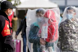 Hành khách đi tàu điện ở TP Thượng Hải trùm kín trong đồ bảo hộ ngày 9-2. Ảnh: REUTERS