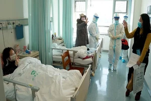 Một phụ nữ đã khỏi bệnh và được cho xuất viện tại một bệnh viện tại TP Vũ Hán. Ảnh: SCMP