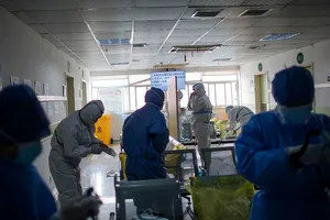 Nhân viên y tế đang tiến hành mặc đồ bảo hộ y tế trước khi bước vào khu vực cách ly ở Hồ Bắc ngày 22-2. Ảnh: AFP