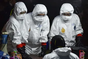 Các nhân viên y tế hướng dẫn một người nghi nhiễm COVID-19 kê khai lịch sử đi lại tại một bệnh viện ở Malaysia ngày 26-2. Ảnh: REUTERS 