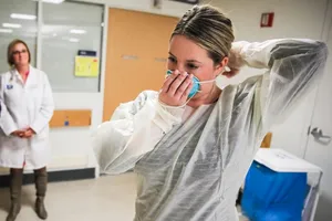 Một bác sĩ hướng dẫn cách đeo khẩu trang đúng cách tại Bệnh viện Massachusetts (Boston) ngày 27-2. Ảnh: REUTERS