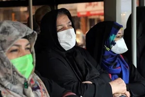 Phụ nữ Iran đeo khẩu trang khi đứng chờ xe bus ở thủ đô Tehran (Iran) ngày 26-2. Ảnh: AP