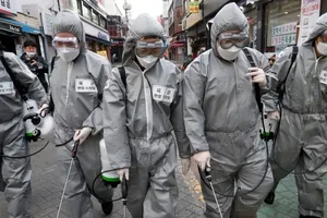 Nhân viên y tế khử trùng đường phố thủ đô Seoul (Hàn Quốc) ngày 4-3. Ảnh: AFP