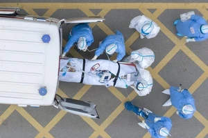 Các nhân viên y tế tiếp nhận một bệnh nhân COVID-19 tại một bệnh viện ở Vũ Hán - nơi bùng phát dịch bệnh. Ảnh: TÂN HOA XÃ 