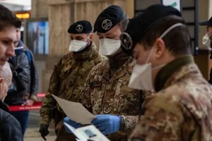 Một số binh sĩ Ý kiểm tra giấy tờ của hành khách đi ga tàu Attilio Fontana ở TP Milan hôm 10-3. Ảnh: AFP 