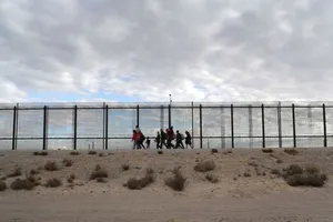 Người di cư từ Trung Mỹ đi dọc bức tường biên giới giữa Mỹ và Mexico. Ảnh: GETTY IMAGES