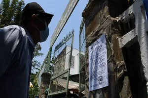 Người dân Campuchia đọc thông báo về đóng cửa trường học do đại dịch COVID-19. Ảnh: AFP