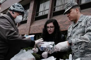 Một quân y Mỹ phát thực phẩm và trang thiết bị y tế cứu trợ cho người vô gia cư ở bang California ngày 14-3. Ảnh: AFP