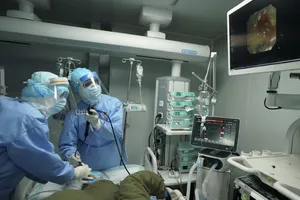 Các bác sĩ thăm khám cho người nghi nhiễm COVID-19 tại bệnh viện dã chiến Hoả Thần Sơn, Vũ Hán ngày 17-3. Ảnh: TÂN HOA XÃ