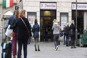 Người dân xếp hàng bên ngoài một cửa hàng bán thịt tại quảng trường Campo de Fiori ở thủ đô Rome (Ý) trong thời gian phong tỏa. Ảnh: REUTERS