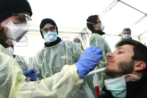 Nhân viên y tế xét nghiệm một người nghi nhiễm COVID-19 ở TP Munich, Đức ngày 29-3. Ảnh: AFP