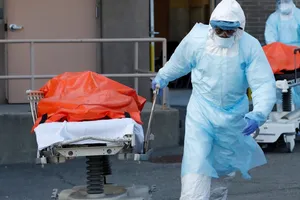 Nhân viên y tế di chuyển một người tử vong vì COVID-19 ở bang New York, Mỹ ngày 3-4. Ảnh: AFP