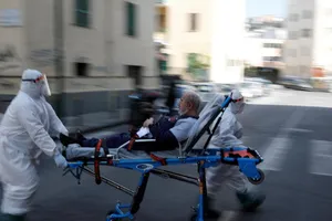 Nhân viên y tế di chuyển một bệnh nhân COVID-19 ở vùng Lombardy, Ý ngày 2-4. Ảnh: AFP